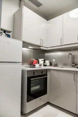 a kitchen with white cabinets and an oven at Erst Guest House in Athens