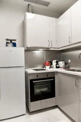 a kitchen with white cabinets and a stove top oven at Erst Guest House in Athens