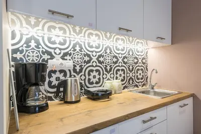 a kitchen with a black and white patterned wall at Filia Place in Athens