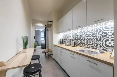 a kitchen with white cabinets and a sink and stools at Filia Place in Athens
