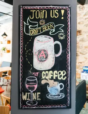 a chalkboard with a drink and a cup of coffee at Athens Hub Hostel in Athens