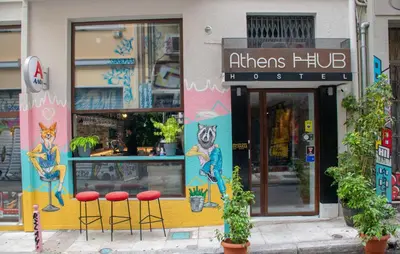 a restaurant with red stools in front of a store at Athens Hub Hostel in Athens