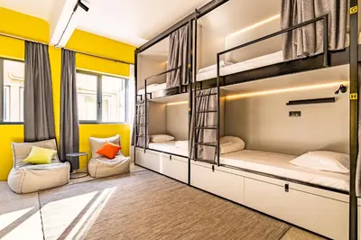two bunk beds in a room with yellow walls at Athens Hub Hostel in Athens