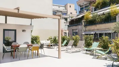 a patio with chairs and a wooden table and chairs at Athens Hub Hostel in Athens