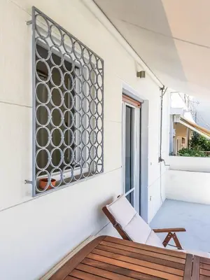 a chair on a balcony with a window at Acropolitana Grand view veranda in Athens