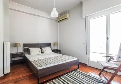 a bedroom with a bed and a chair at Acropolitana Grand view veranda in Athens