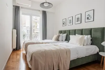 two beds in a bedroom with a green headboard at Charming & Comfy 2BD Apartment in Acropolis Area by UPSTREET in Athens