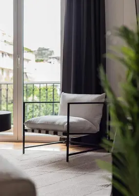 a white chair sitting in front of a window at Charming & Comfy 2BD Apartment in Acropolis Area by UPSTREET in Athens
