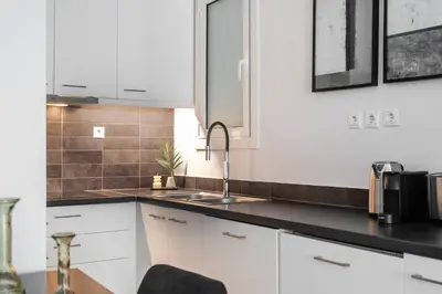 a kitchen with white cabinets and a sink at Charming & Comfy 2BD Apartment in Acropolis Area by UPSTREET in Athens