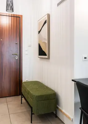 a room with a green ottoman next to a door at Charming & Comfy 2BD Apartment in Acropolis Area by UPSTREET in Athens
