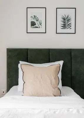 a bedroom with a white bed with two pictures on the wall at Charming & Comfy 2BD Apartment in Acropolis Area by UPSTREET in Athens