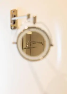 a mirror hanging on a wall in a bathroom at Charming & Comfy 2BD Apartment in Acropolis Area by UPSTREET in Athens