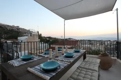 a table with blue bowls and plates on a balcony at Plaka Two-Storey Penhouse with Acropolis Views PL6 in Athens