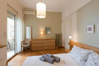 a bedroom with a bed with two pillows on it at Stylish flat with veranda in the heart of Athens in Athens