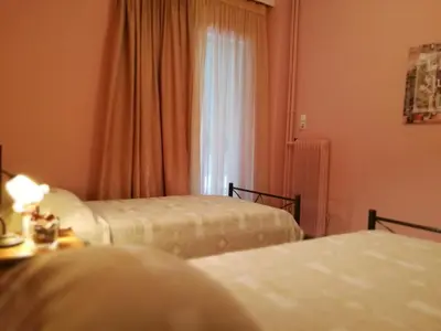 a hotel room with two beds and a window at Platos Academy Apartment in Athens
