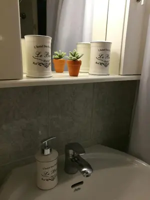 a bathroom sink with four cups on a shelf at Platos Academy Apartment in Athens