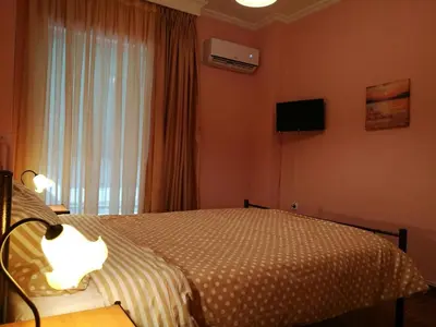 a bedroom with a bed and a television and a window at Platos Academy Apartment in Athens