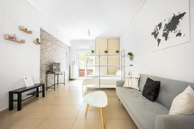 a living room with a couch and a table at Cozy Studio in Central Glyfada in Athens