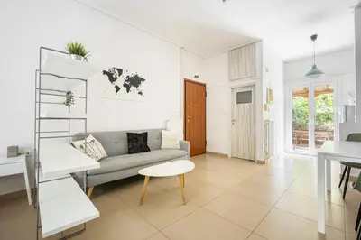 a white living room with a couch and a table at Cozy Studio in Central Glyfada in Athens