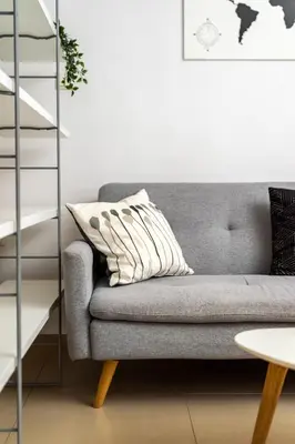 a living room with a gray couch and a ladder at Cozy Studio in Central Glyfada in Athens
