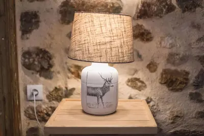 a white vase with a deer on it on a table at Stone House Under Acropolis in Athens