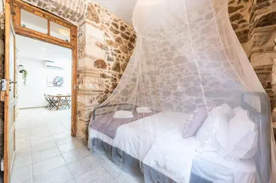 a bedroom with a bed with a mosquito net at Stone House Under Acropolis in Athens