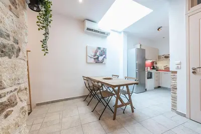 a kitchen with a wooden table and a refrigerator at Stone House Under Acropolis in Athens