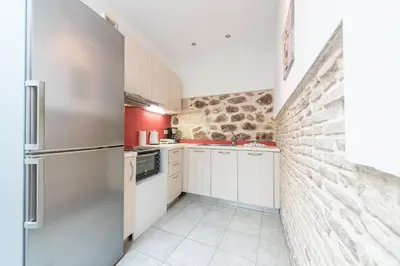 a kitchen with white appliances and a brick wall at Stone House Under Acropolis in Athens