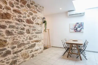 a dining room with a table and a stone wall at Stone House Under Acropolis in Athens