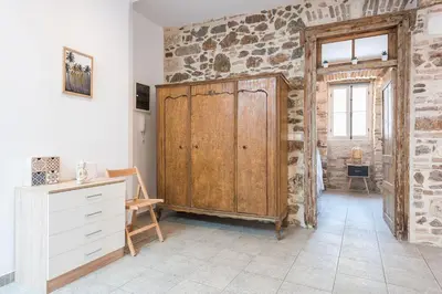 a room with a wooden door in a stone wall at Stone House Under Acropolis in Athens