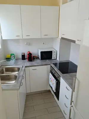 a small kitchen with a sink and a microwave at Uncle Tom's Penthouse in Piraeus
