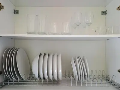 a shelf with plates and glasses on it at Uncle Tom's Penthouse in Piraeus