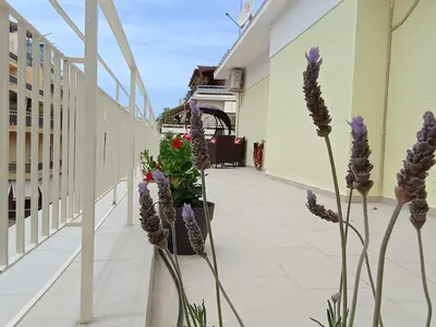 a walkway with purple flowers on the side of a building at Uncle Tom's Penthouse in Piraeus
