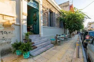 a building with a green door and stairs on a street at Troon of Athens Apartments in Athens