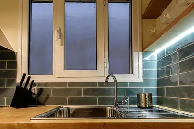 a kitchen with a sink and two windows at Photographers House in Athens