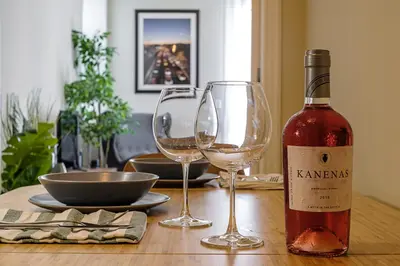 a bottle of wine and two wine glasses on a table at Photographers House in Athens