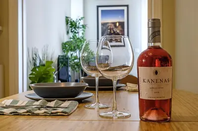 a bottle of wine and two wine glasses on a table at Photographers House in Athens