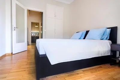 a bedroom with a large white bed with blue pillows at Photographers House in Athens