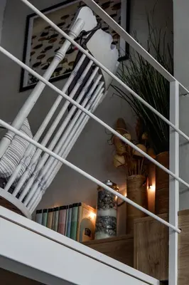 a white spiral staircase with books in a room at Magtsi apartment in Athens