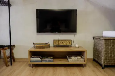 a living room with a tv and a table with books at Magtsi apartment in Athens