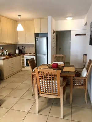 a kitchen with a wooden table and chairs and a refrigerator at Elenis Athens Apartment in Athens