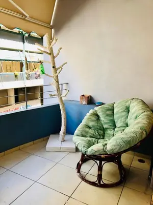 a green chair in a room with a tree at Elenis Athens Apartment in Athens