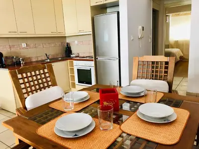 a kitchen with a wooden table with plates on it at Elenis Athens Apartment in Athens