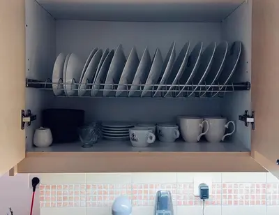 a kitchen shelf with plates and cups and dishes at Elenis Athens Apartment in Athens