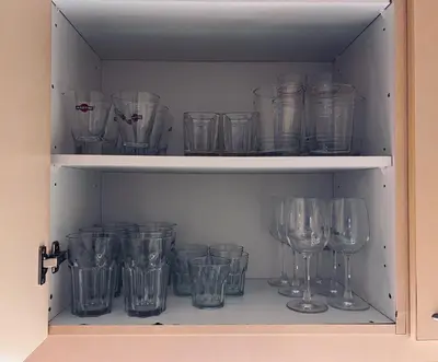 a cupboard filled with lots of empty wine glasses at Elenis Athens Apartment in Athens
