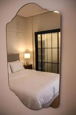 a mirror reflecting a bed in a bedroom at API Projects Athens - Cartier Apartment in Athens