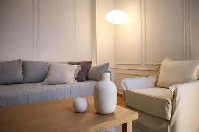 a living room with a couch and a vase on a coffee table at API Projects Athens - Cartier Apartment in Athens