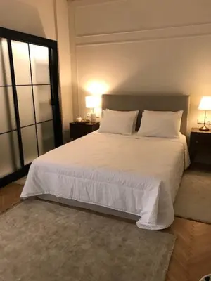 a bedroom with a large white bed with two lamps at API Projects Athens - Cartier Apartment in Athens