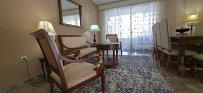 a living room with chairs and a table and a piano at Cosy apartment in Chalandri in Athens