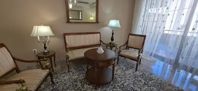 a living room with chairs and a table and a mirror at Cosy apartment in Chalandri in Athens